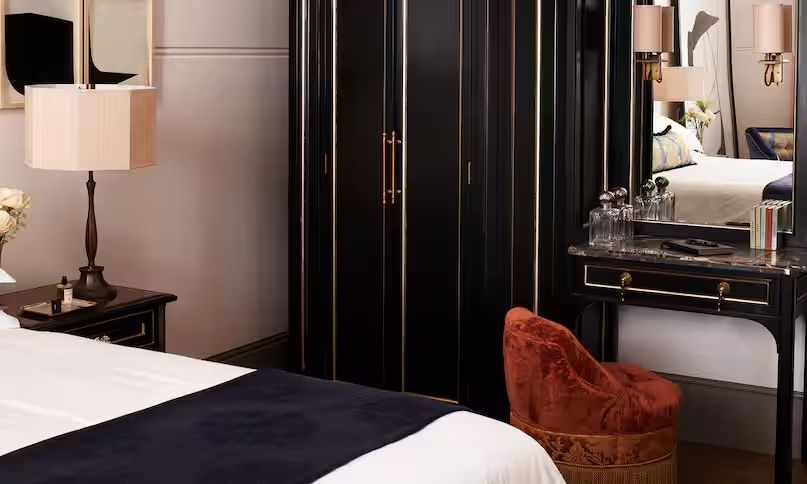Luxuriöses Zimmerdetail mit schwarzem Kleiderschrank und gemütlichem Sessel