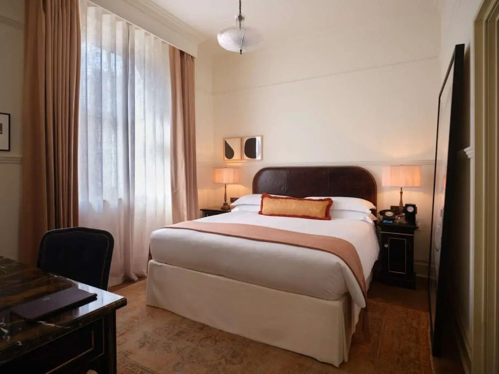 Elegantes Schlafzimmer mit Kingsize-Bett und weichen Vorhängen im NoMad London Hotel