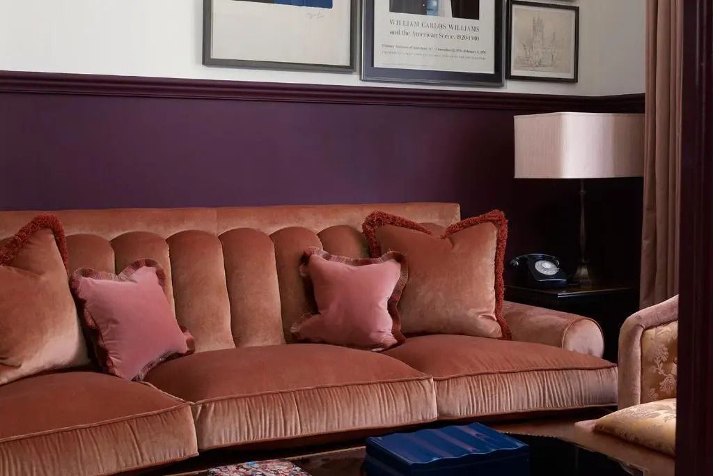Komfortable rosafarbene Couch mit dekorativen Kissen im NoMad London Hotel