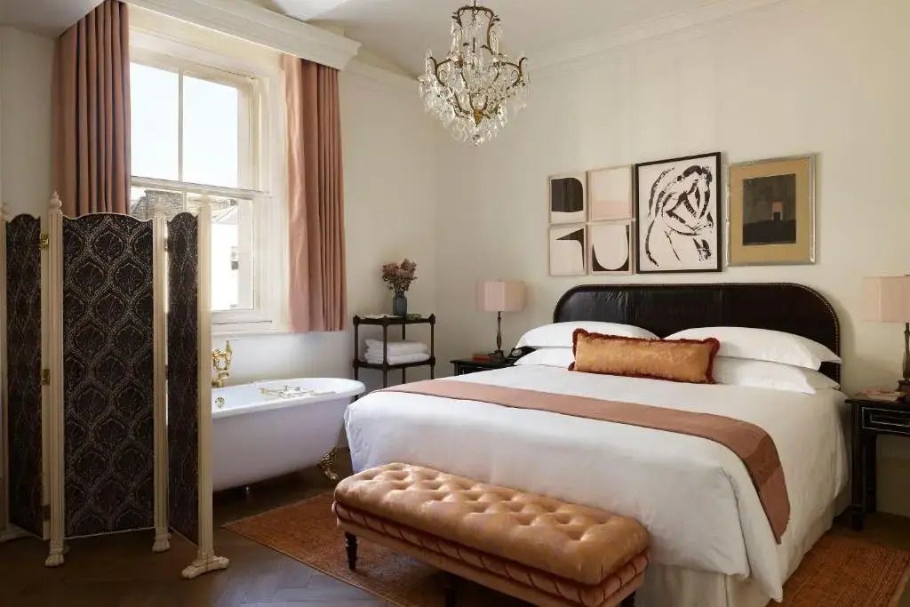 Elegante Suite mit freistehender Badewanne, großem Bett und luxuriösem Kronleuchter