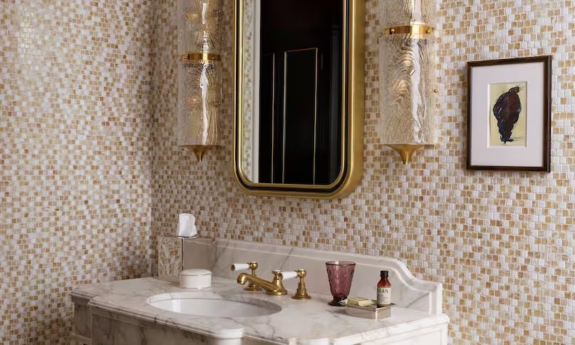 Hochwertiges Badezimmer mit goldenen Akzenten und Mosaikwänden.