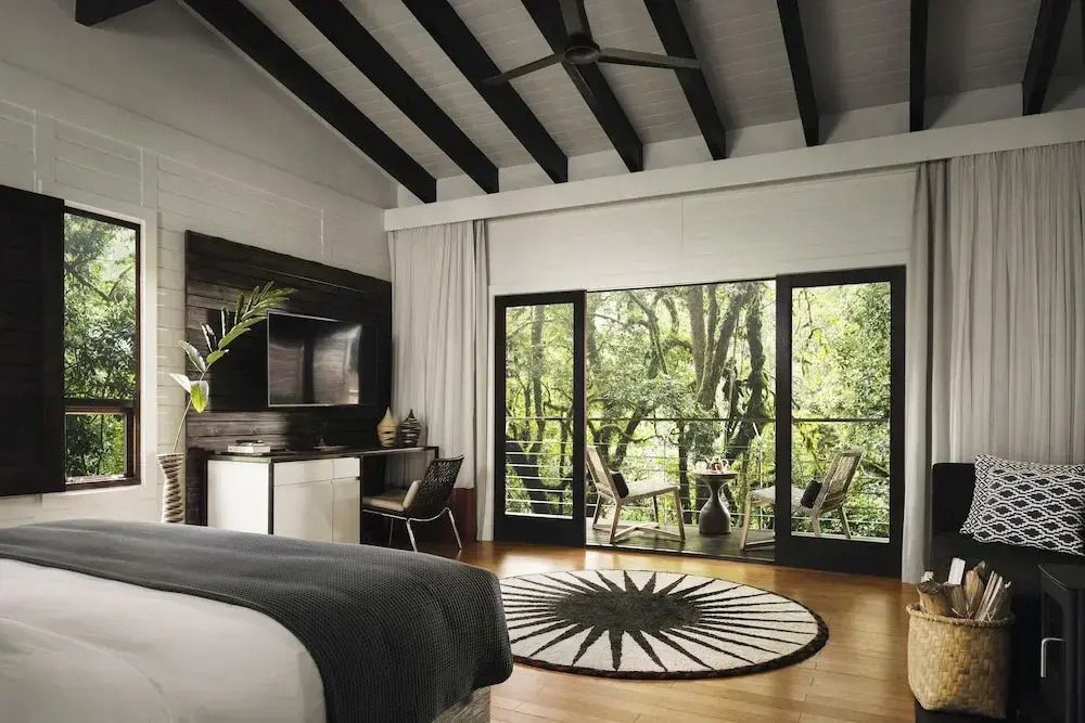 Großes Schlafzimmer mit Blick auf grünen Wald
