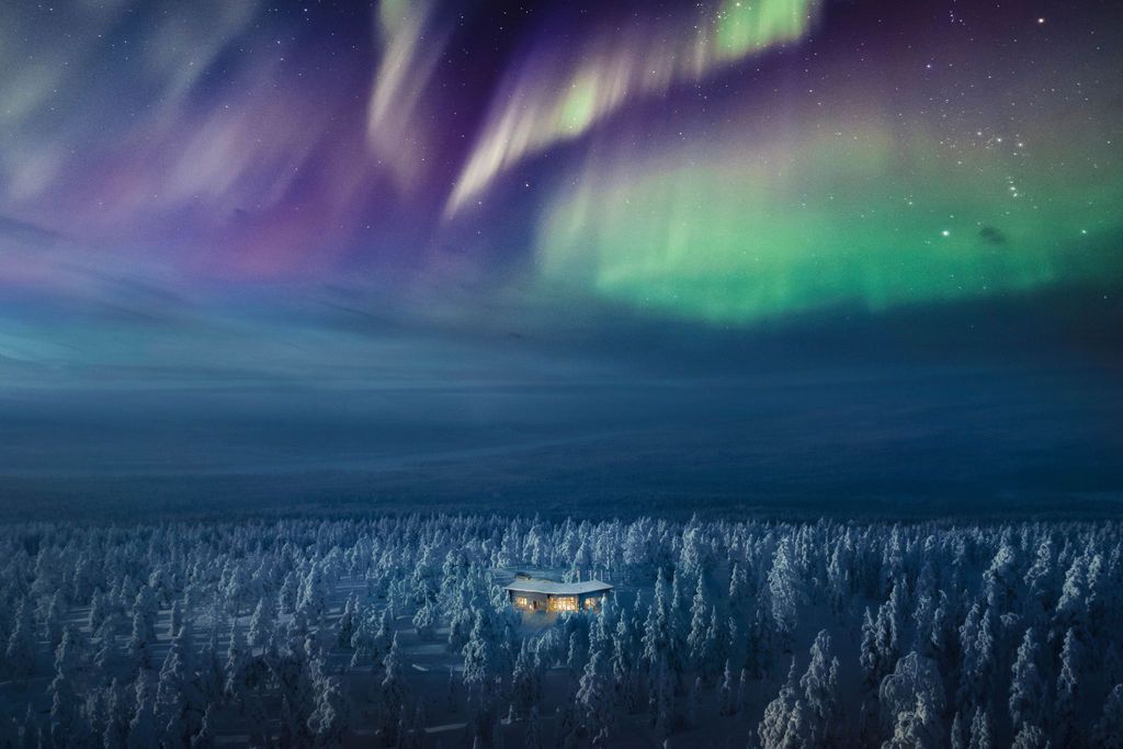 Nordlichter über dem Wald, darunter die beleuchtete Octola Villa in der verschneiten Landschaft