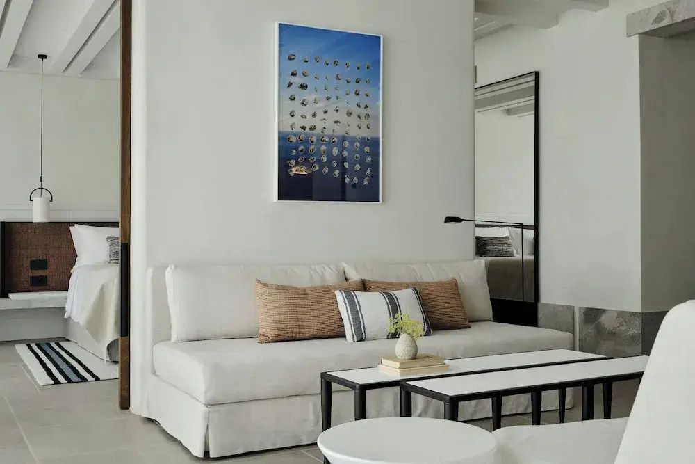 Wohnbereich einer Suite mit stilvollem Sofa und modernen Kunstwerken