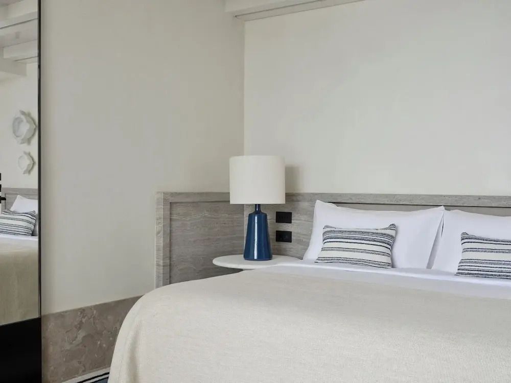 Hell beleuchtetes Zimmer Doppelbett mit stilvoller Lampe und dekorativem Kissen