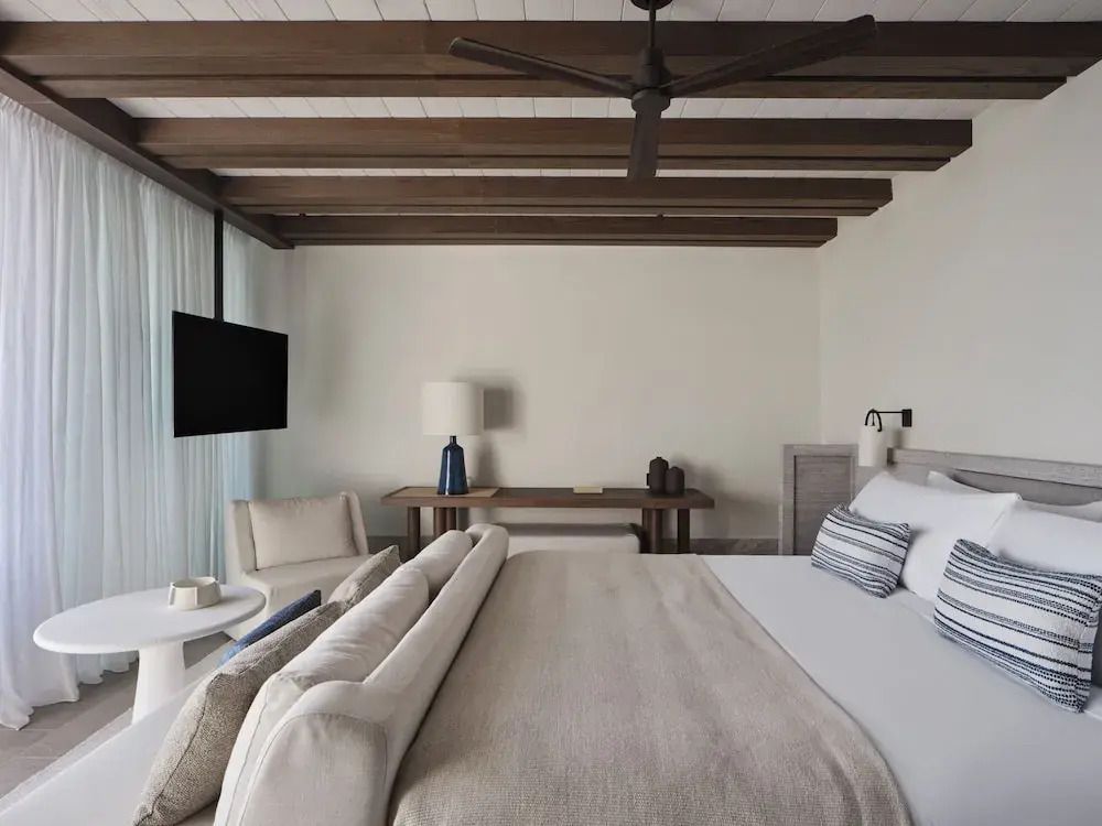 Geräumiges Schlafzimmer mit Holzbalkendecke und modernem Design