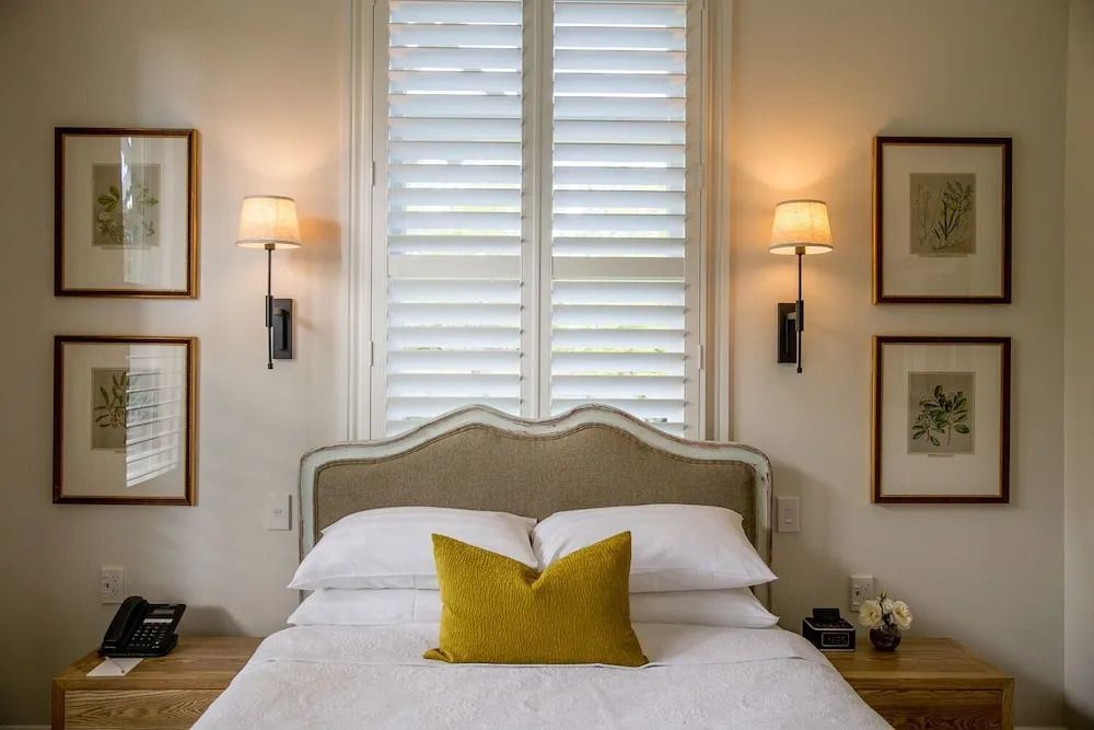 Doppelbett in elegantem Zimmer mit dezenter Beleuchtung und Kunstwerken