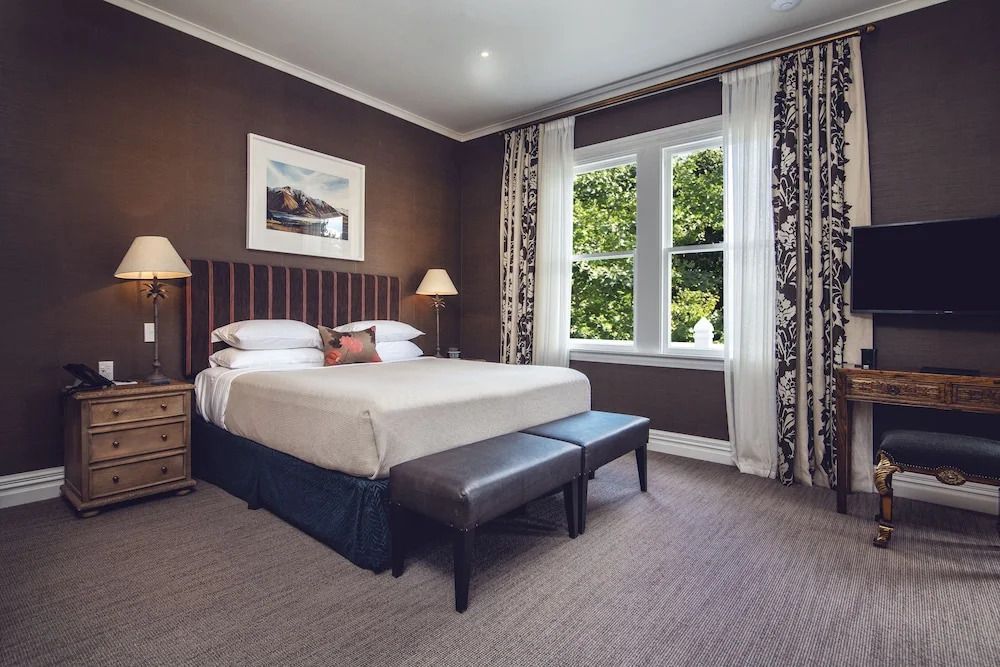 Premium Doppelzimmer mit stilvollem Bett und Aussicht auf den grünen Garten