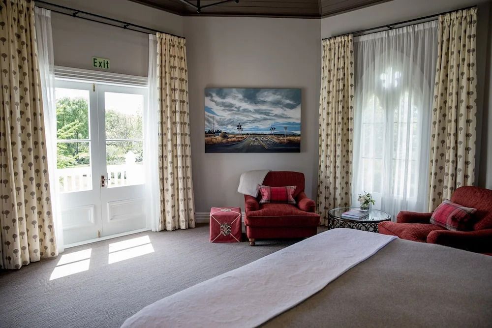 Großzügiges Zimmer mit bequemen Sesseln und Zugang zur Terrasse mit Gartenblick