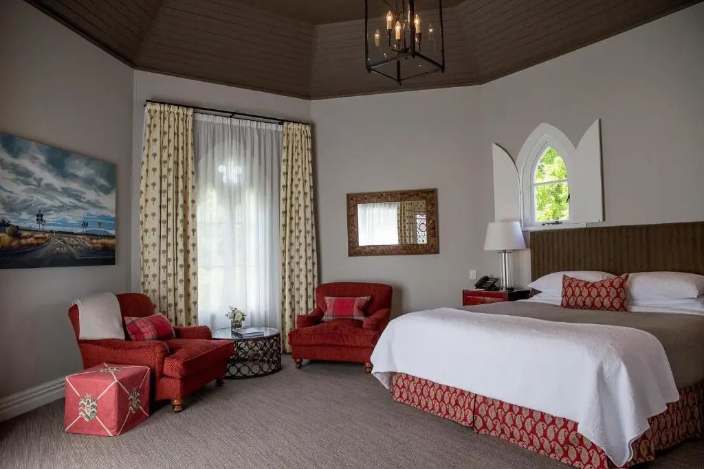 Elegantes Schlafzimmer mit roten Akzenten und hohen Decken
