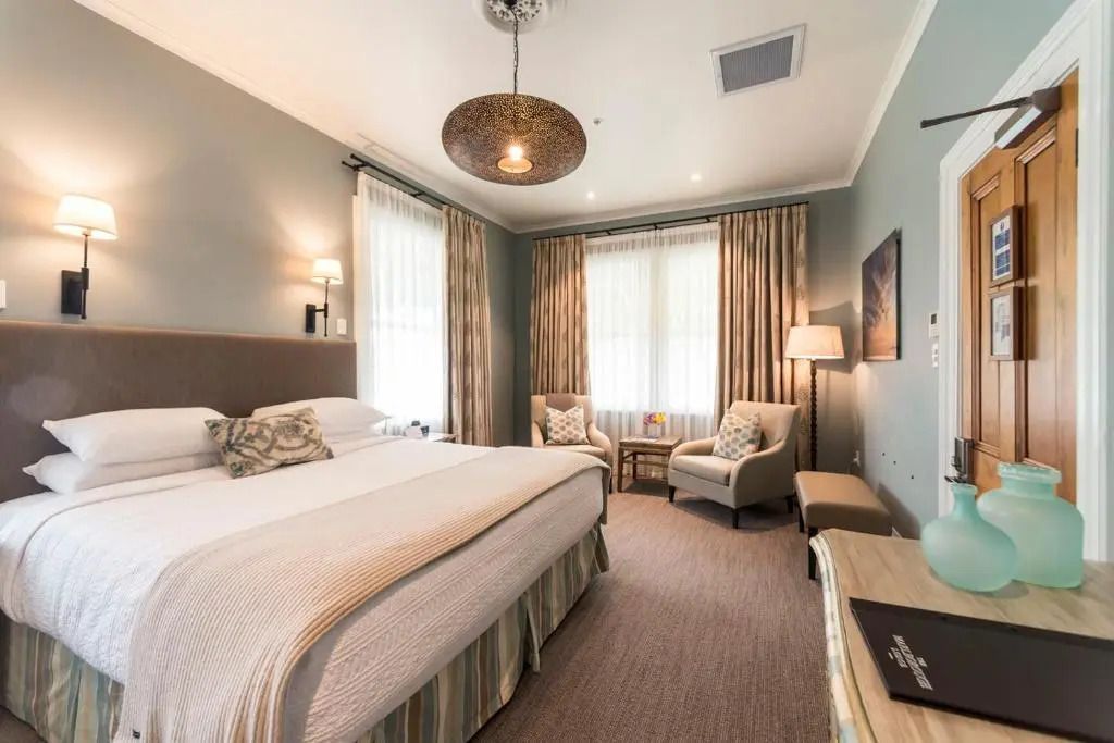 Helles Schlafzimmer mit großem gemütlichem Bett und Sitzbereich