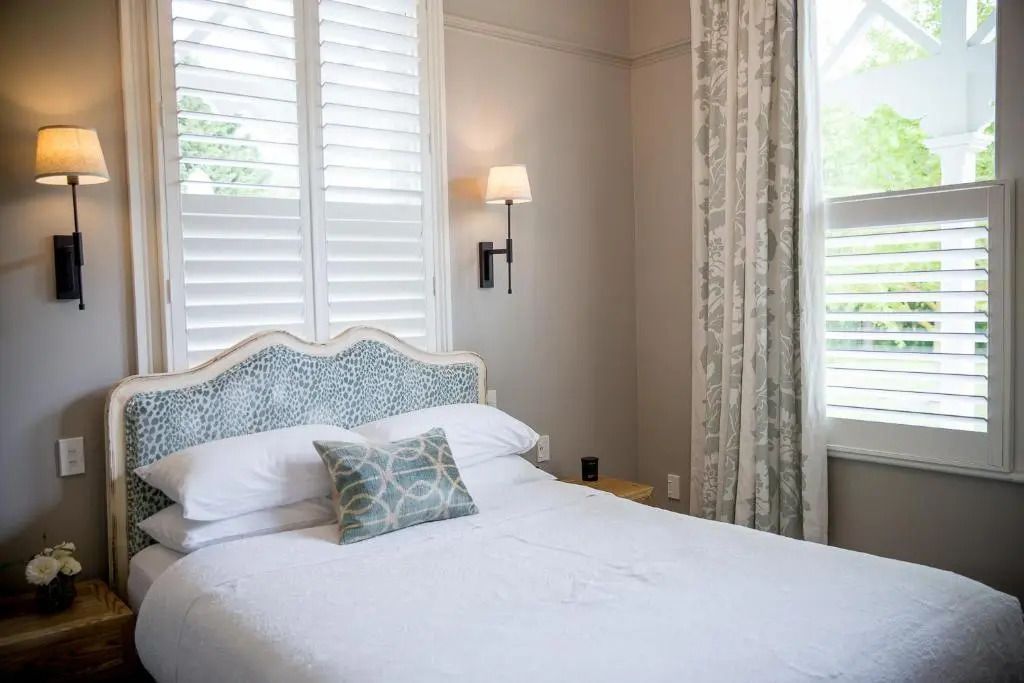 Helles Schlafzimmer mit weißem Doppelbett und elegantem Kopfteil