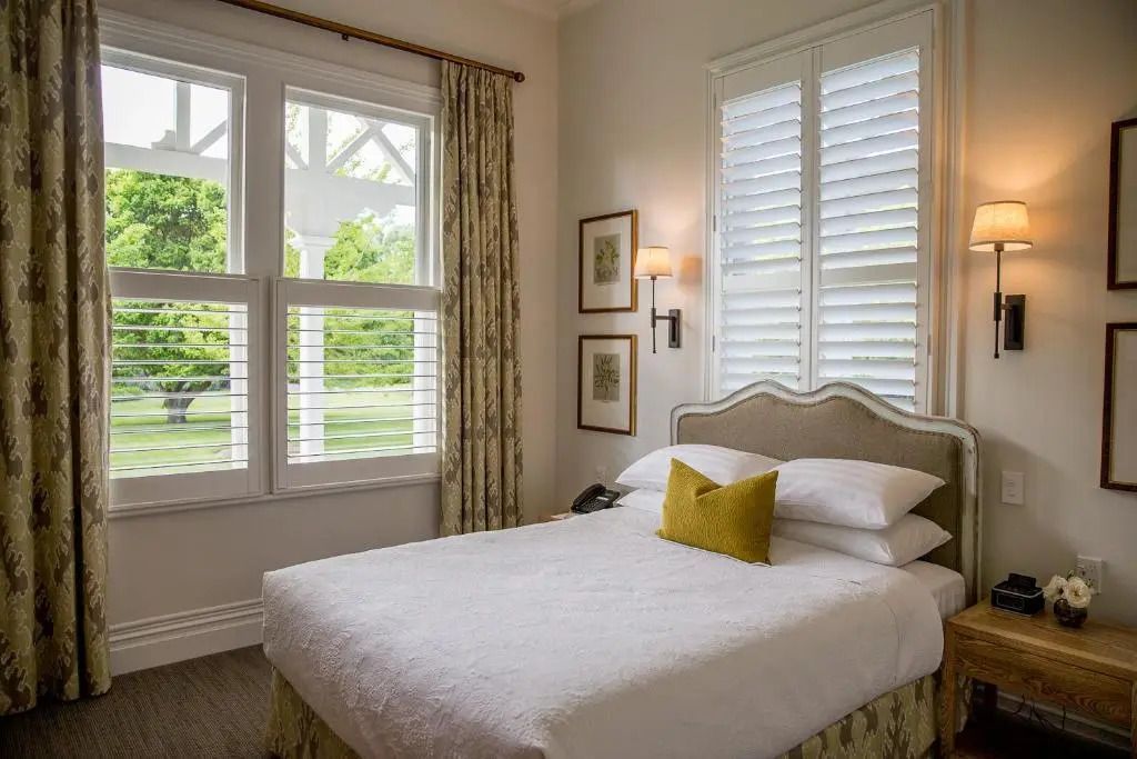 Gemütliches Zimmer mit Doppelbett, Kissen und herrlichem Gartenblick