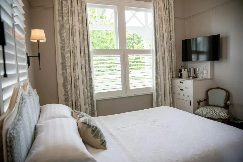 Luxuriöses Doppelzimmer mit Bett, TV und Gartenblick
