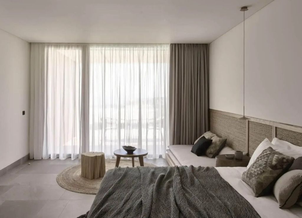 Helle Suite mit Panoramafenstern und eleganten Vorhängen.