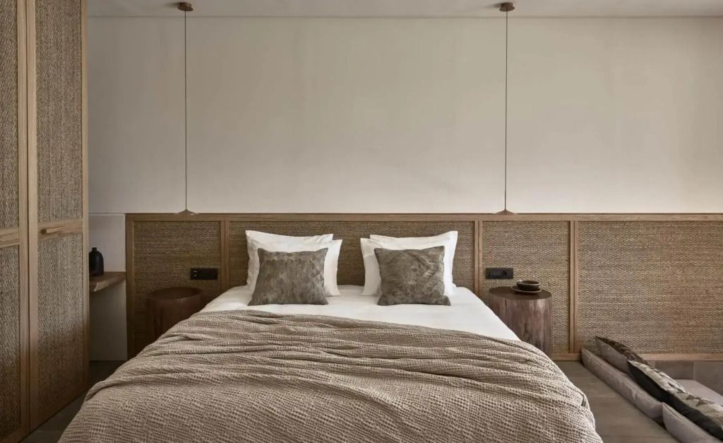 Gemütliches Doppelbett mit stilvollen Kissen und natürlichem Design.
