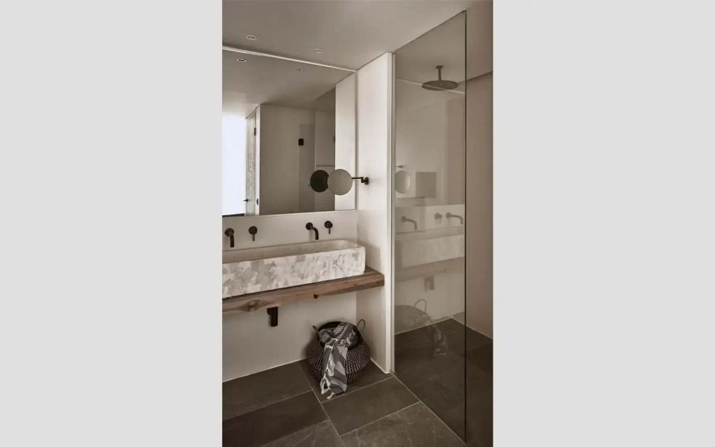 Modernes Badezimmer mit eleganter Dusche und stilvollem Waschbereich.