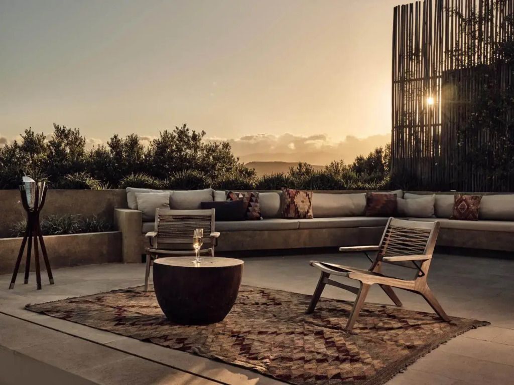 Gemütliche Terrasse mit bequemer Sitzgelegenheit und atemberaubendem Sonnenuntergang