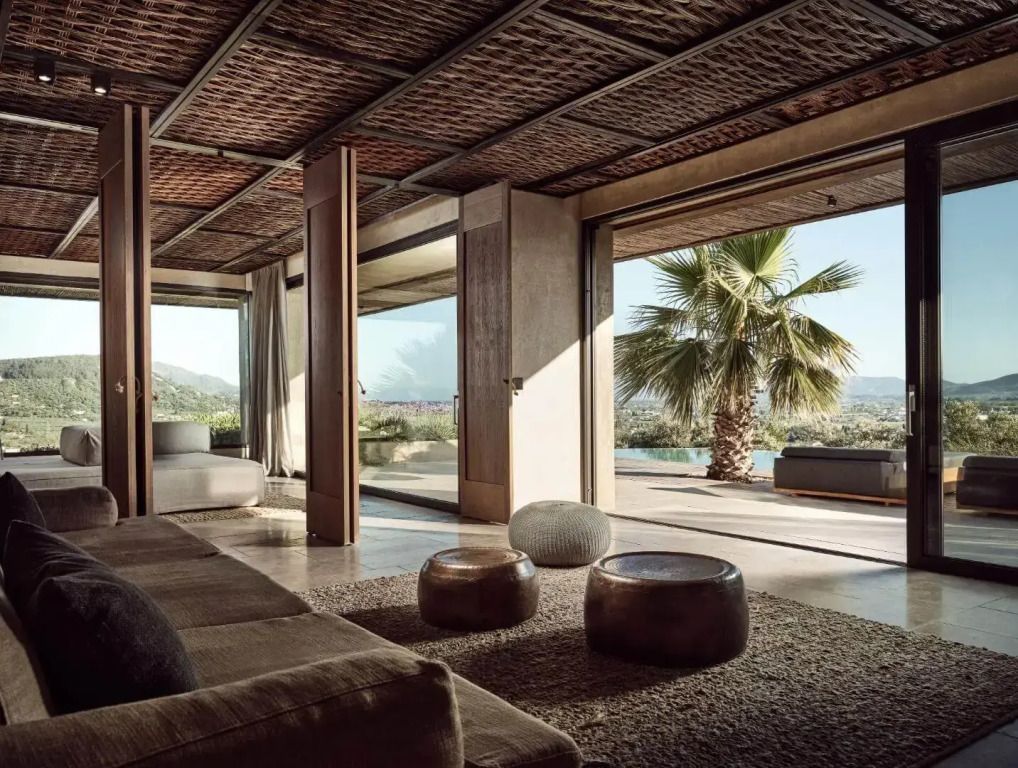 Geräumiges Wohnzimmer mit großen Fenstern und Blick auf den Pool und die Natur