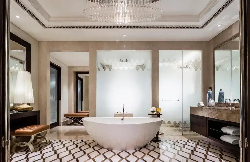 Luxuriöses Badezimmer mit freistehender Badewanne und prächtigem Kronleuchter