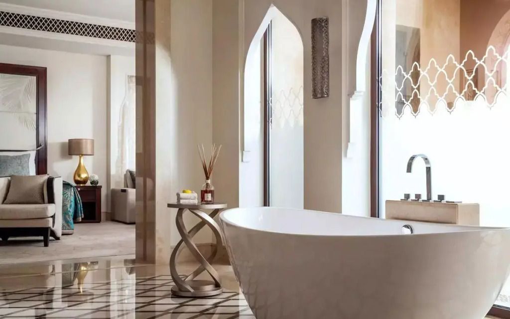Luxuriöses Badezimmer mit freistehender Badewanne und eleganten Details im arabischen Stil.