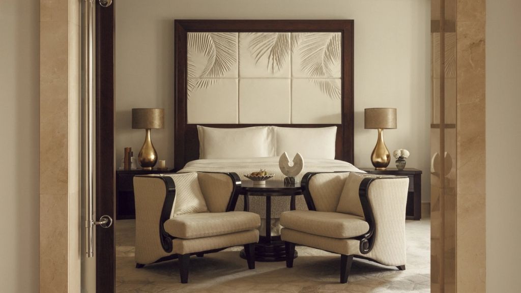 Elegantes Schlafzimmer mit Doppelbett, stilvollen Sesseln und edlen Nachttischlampen