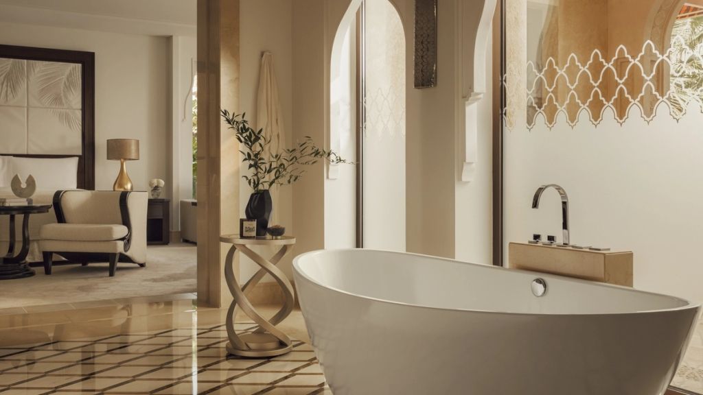Luxuriöses Badezimmer mit geschwungener freistehender Badewanne und edlen Dekorationen