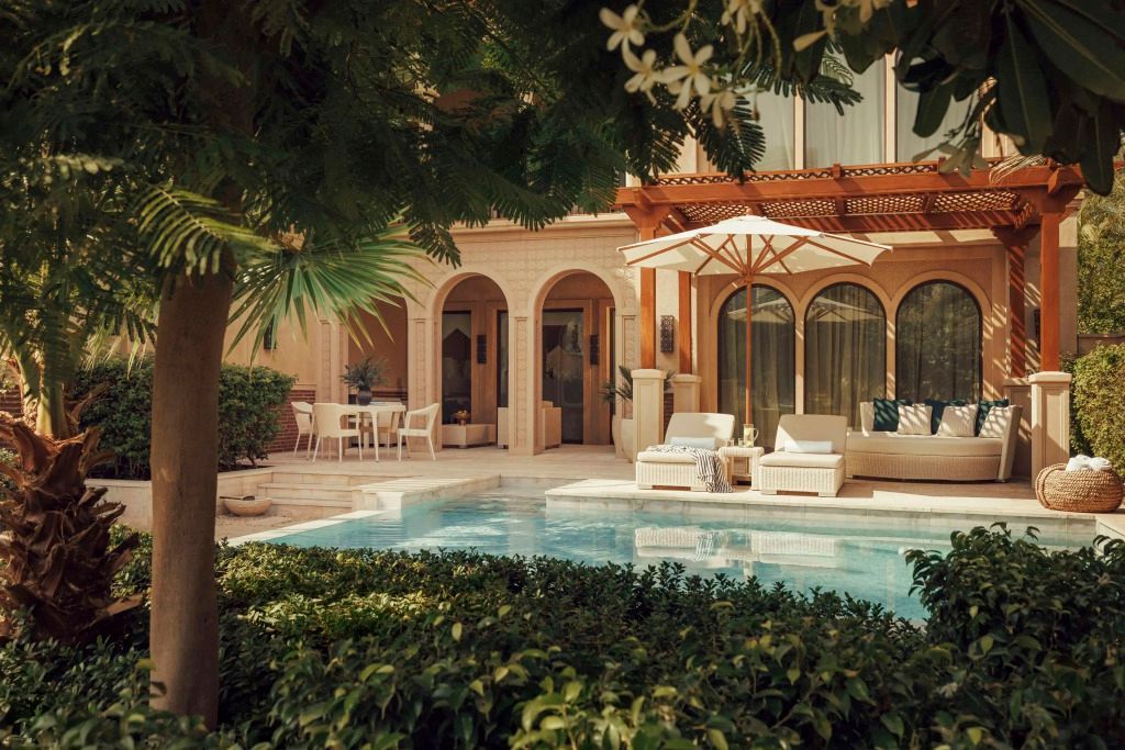 Privater Pool mit üppigem Garten und stilvollem Loungemöbeln