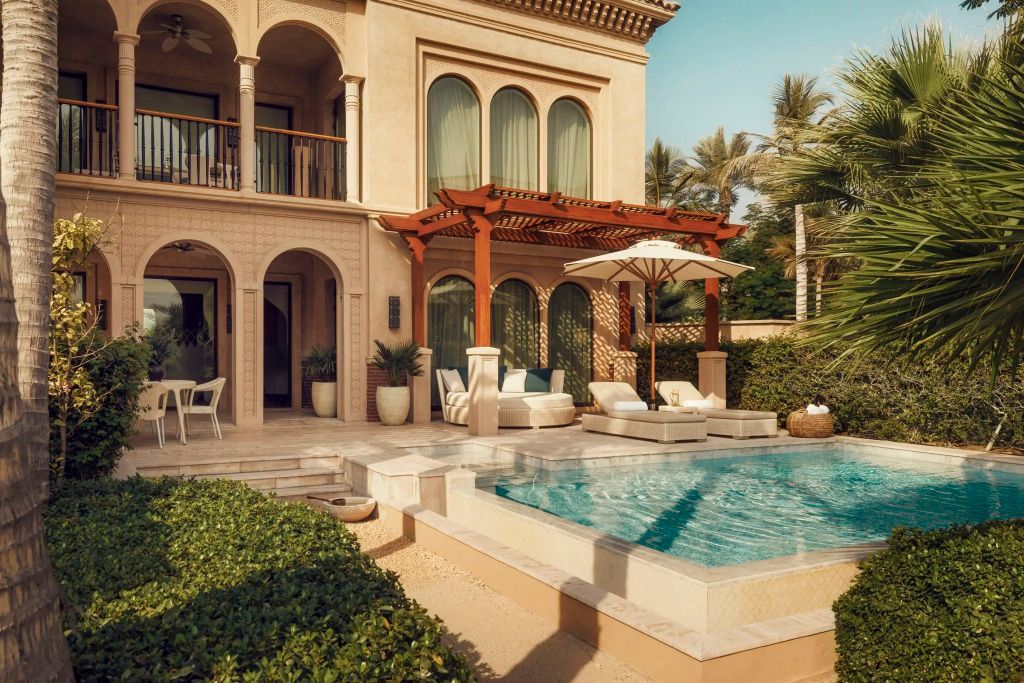 Sonnige Terrasse mit Pool und gemütlichen Liegen, umgeben von Palmen