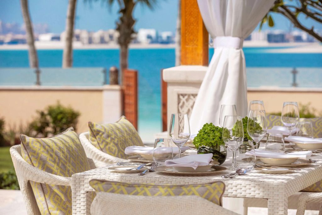 Strandnahe Terrasse mit gedecktem Tisch und Blick auf das Meer im Hotel One&Only The Palm.