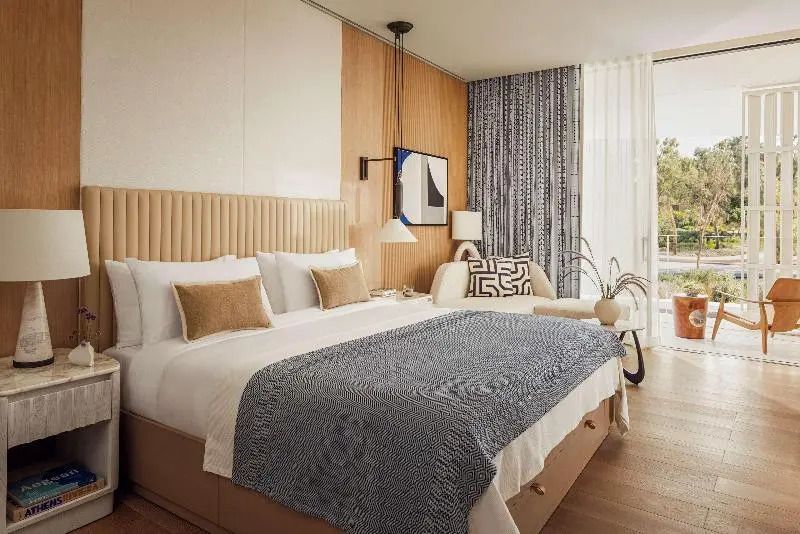Elegantes Doppelbettzimmer mit moderner Kunst und großen Fenstern.