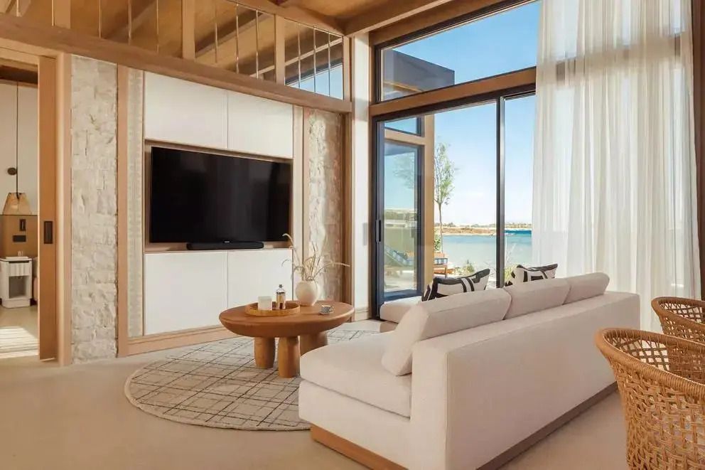Moderner Wohnbereich mit Meerblick und großem TV in der Riviera Suite