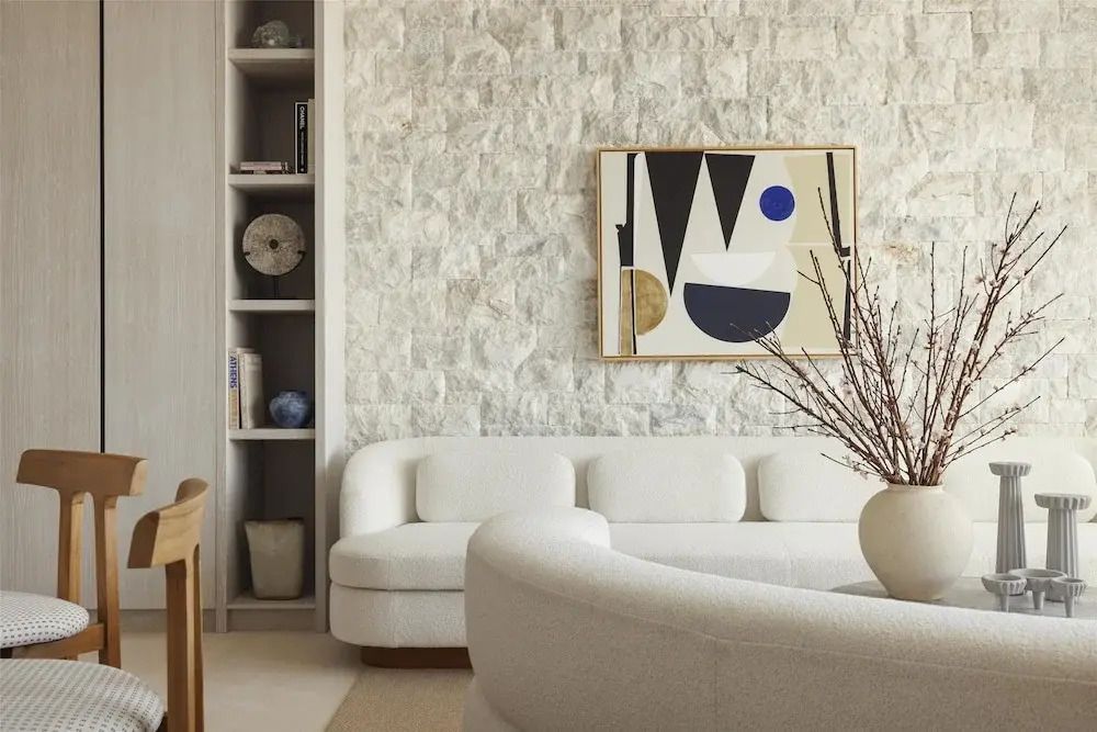 Moderne Lounge mit Kunst an der Steinwand und gemütlichem Sofa