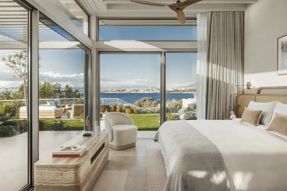 Lichtdurchflutetes Schlafzimmer mit Panoramafenster und Blick auf das Meer