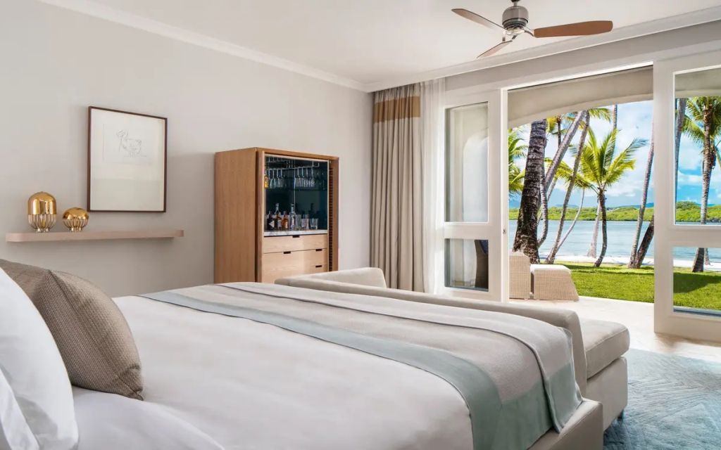 Lagoon Doppelzimmer mit Balkon, Doppelbett mit Blick auf tropische Vegetation und Meer