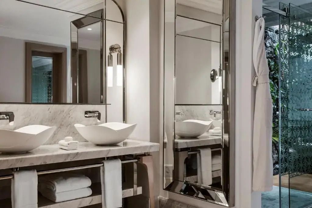 Elegantes Badezimmer mit modernen Waschbecken und Spiegeln in der Villa One