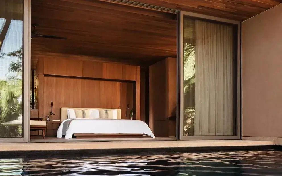 Luxuriöses Schlafzimmer mit Doppelbett und direktem Zugang zum Pool