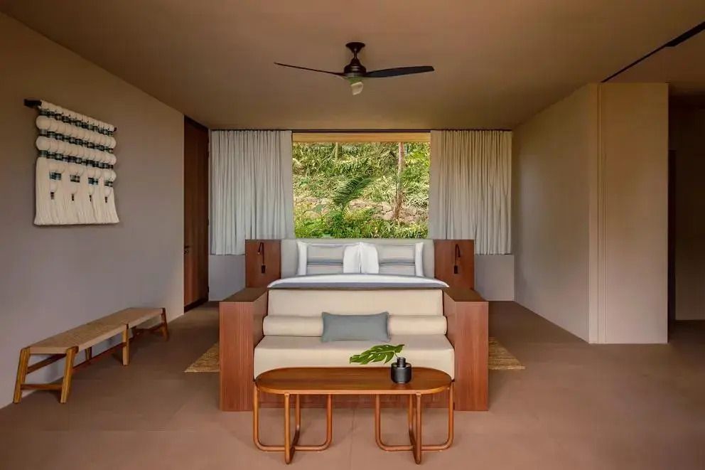 Modernes Schlafzimmer mit großem Bett und Blick ins Grüne