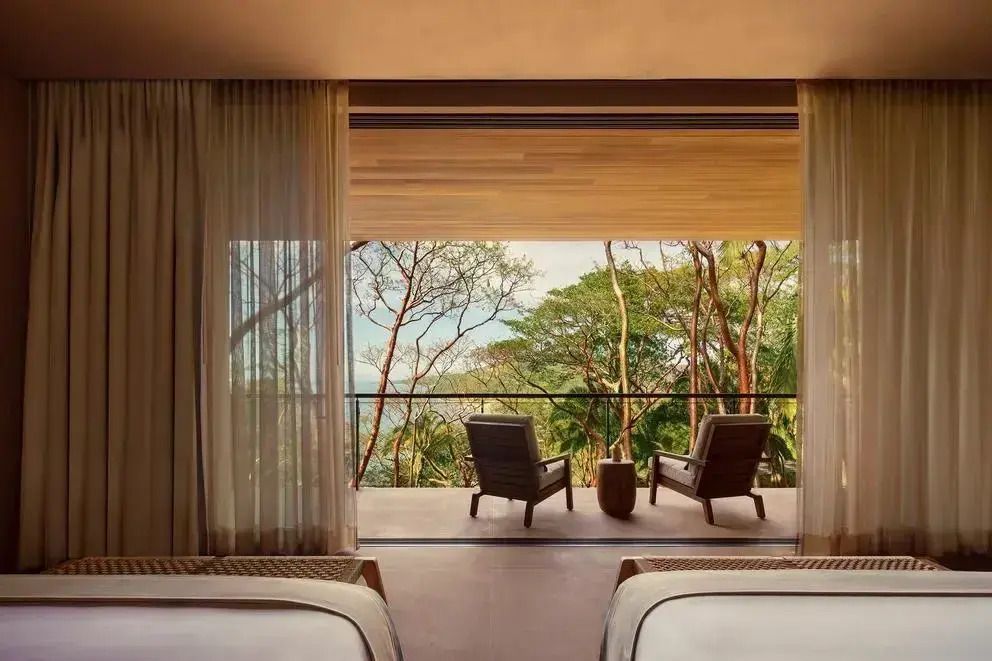 Private Terrasse mit zwei Sesseln und Blick auf den Wald und das Meer