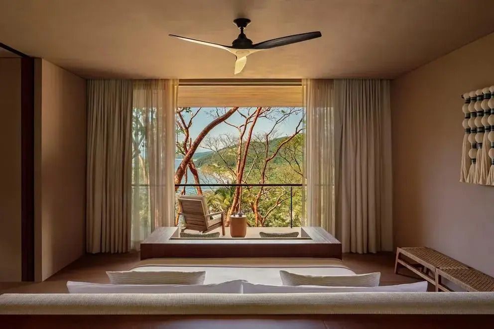 Geräumiges Zimmer mit Panoramafenstern und Blick auf Meer und Wald