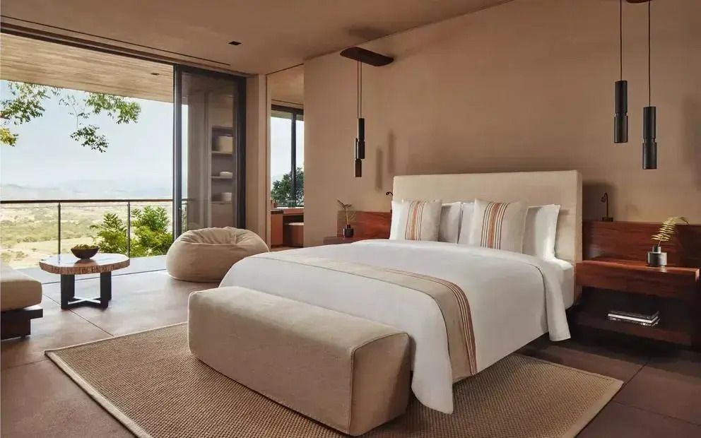 Luxuriöses Schlafzimmer mit weißem Bett und Zugang zur Terrasse