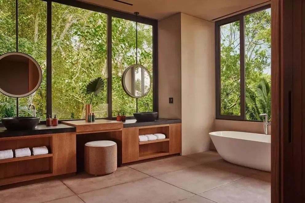 Helles Badezimmer mit freistehender Badewanne und großen Fenstern