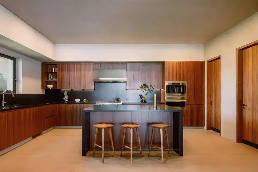 Moderne, geräumige Küche mit dunklen Holzschränken und Insel