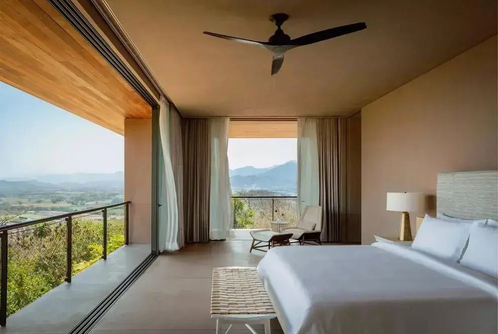 Geräumiges Schlafzimmer mit großem Fenster und Blick auf die Berge