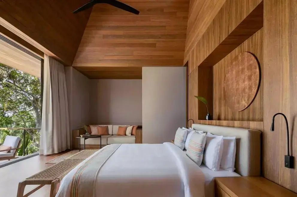 Geräumiges Schlafzimmer mit Holzwänden und gemütlichem Sofa