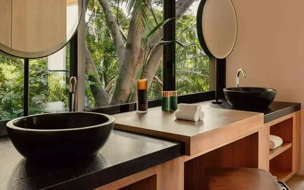 Modernes Bad mit zwei Waschbecken und großen Fenstern zur Natur