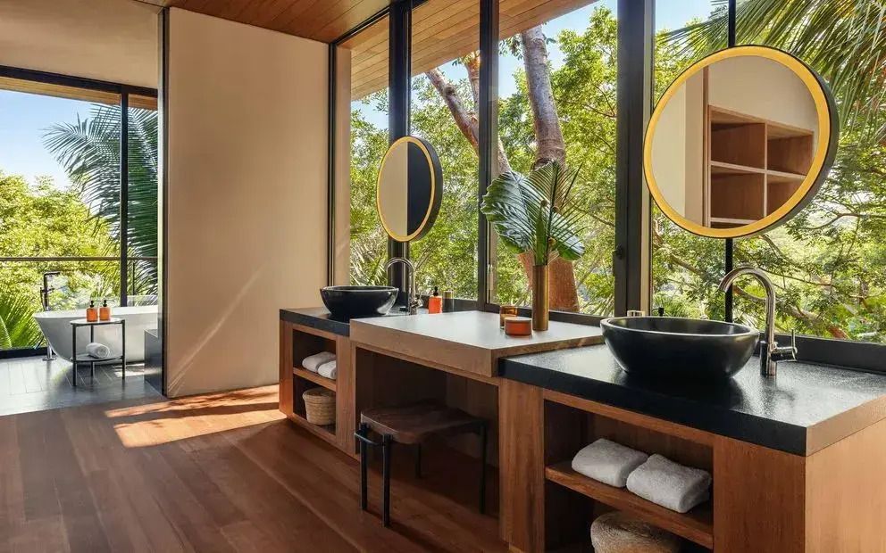 Luxuriöses Badezimmer mit großen Fenstern und Doppelwaschbecken