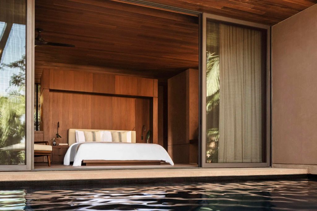 Luxuriöses Schlafzimmer mit Holzverkleidung und Poolzugang in der Ocean Banderas Villa