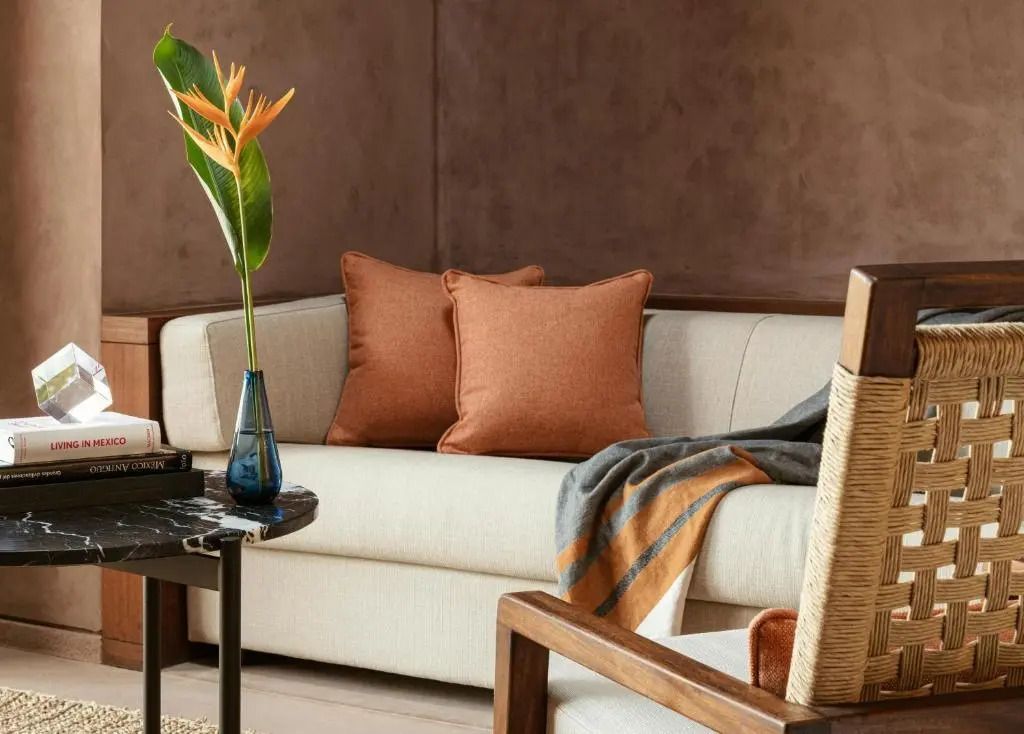 Gemütliche Sitzecke mit beigen Sofa und orangen Kissen in der Villa