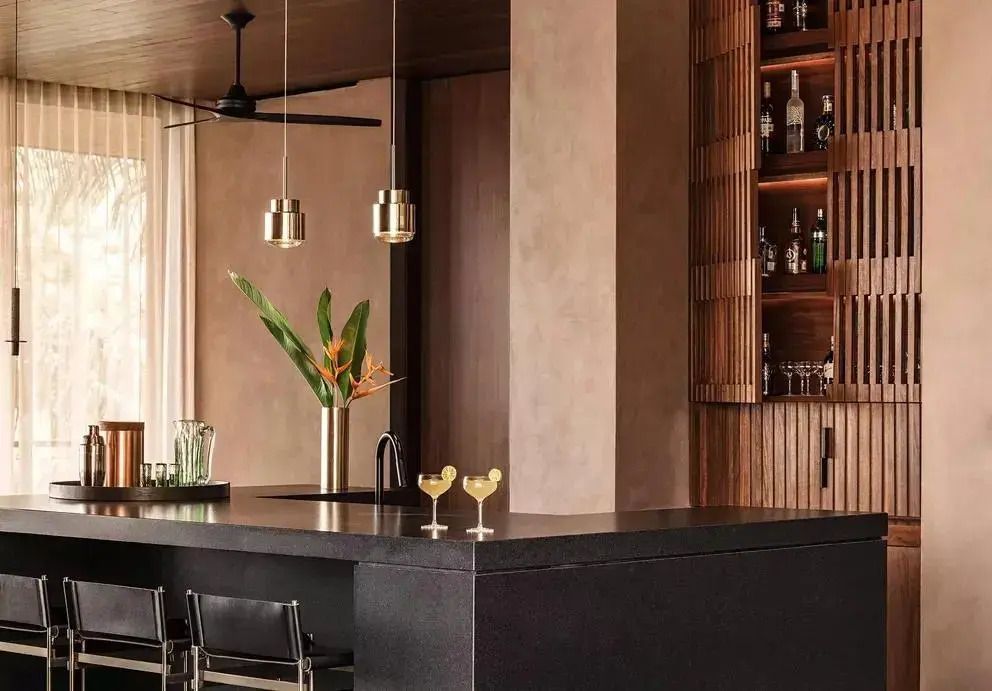 Stilvolle Bar mit Regalen voller Flaschen und zwei Cocktails auf der Theke